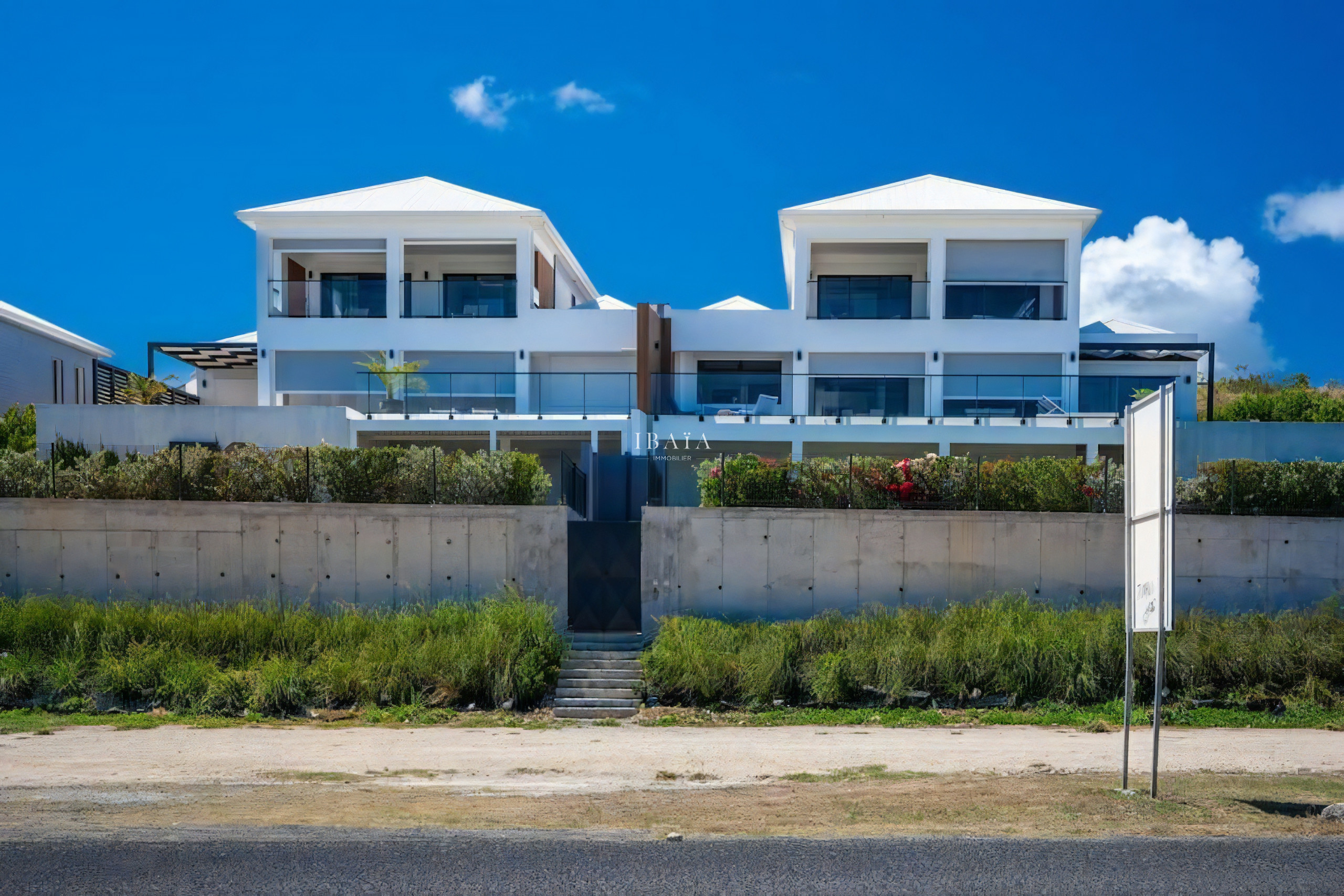 Facade of two modern residences with a garden in front.