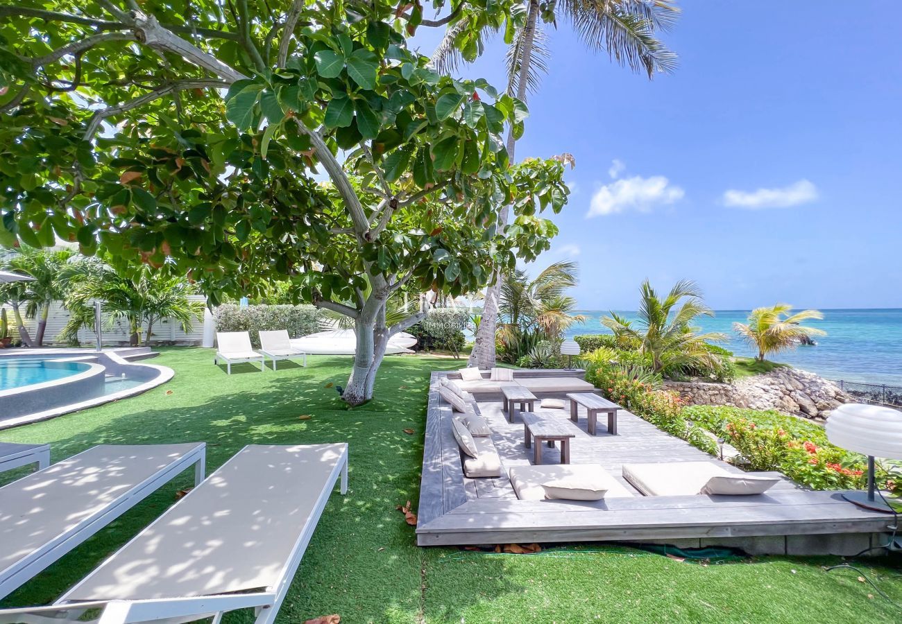 Outdoor lounge and sunbeds with sea view in a well-kept tropical garden