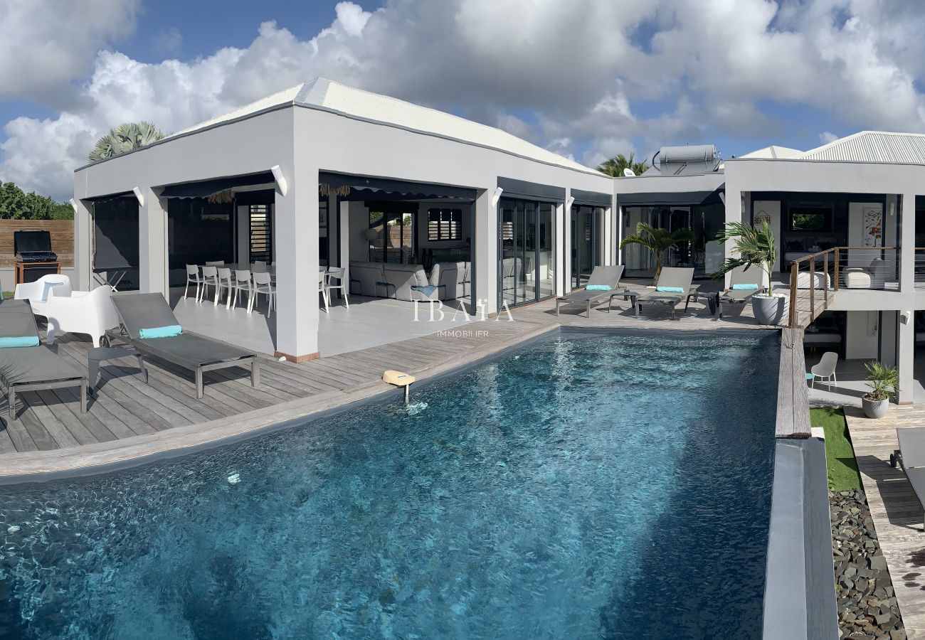 Aerial view luxury villa infinity pool sunbeds wooden terrace