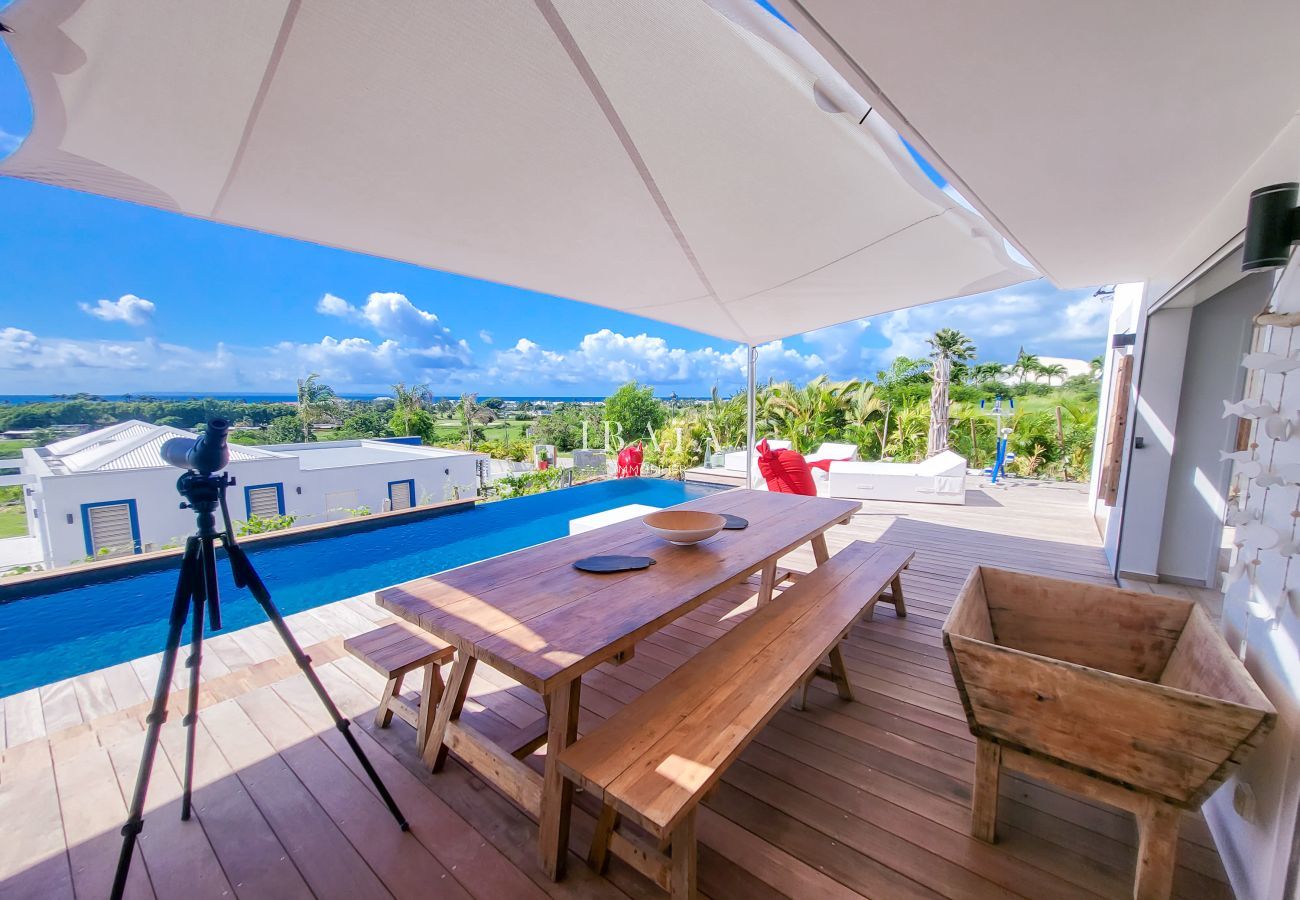 Modern dining room, wooden table, view of terrace and pool