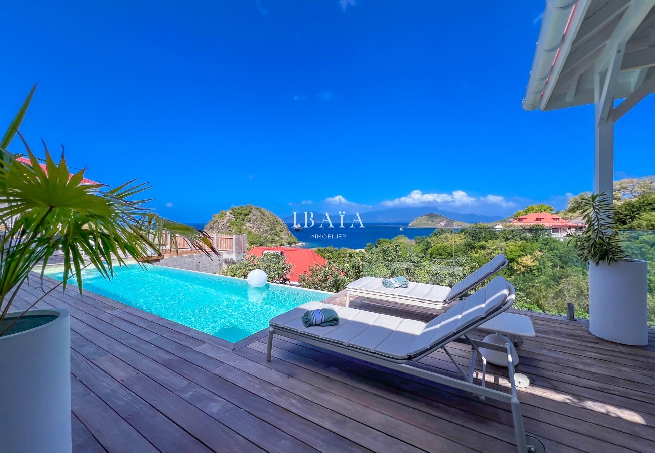 Sun lounger facing a pool and panoramic sea view