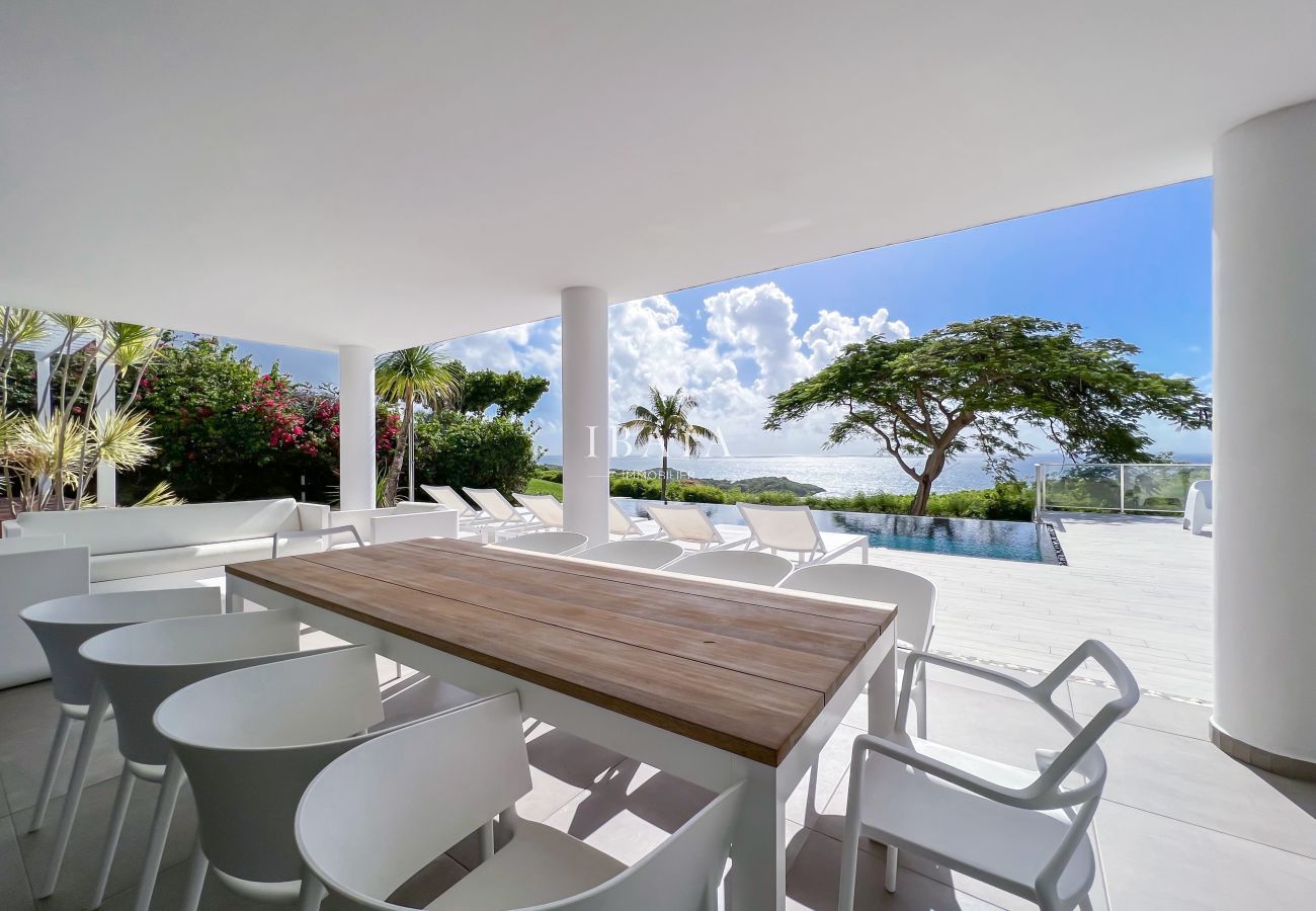 Mesa de comedor para 10 personas en la terraza con vistas a la piscina y al mar