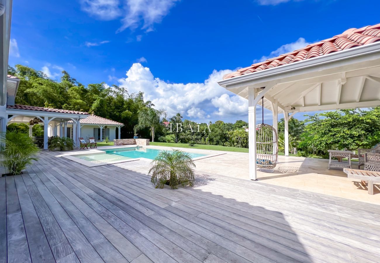 Gran terraza de madera y patio con muebles de jardín con vistas a la piscina