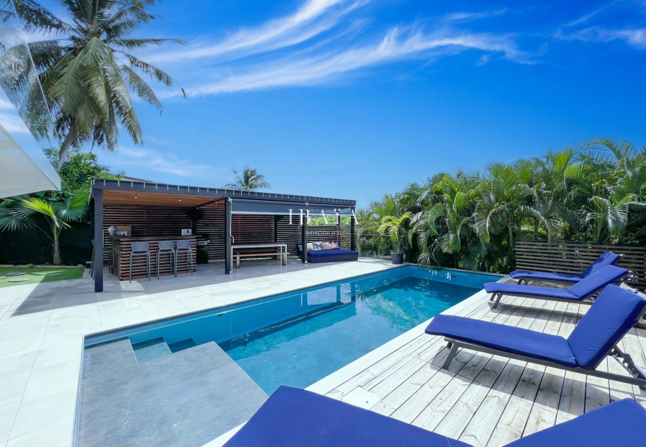 Pérgola con cocina totalmente equipada y comedor alrededor de la piscina con tumbonas