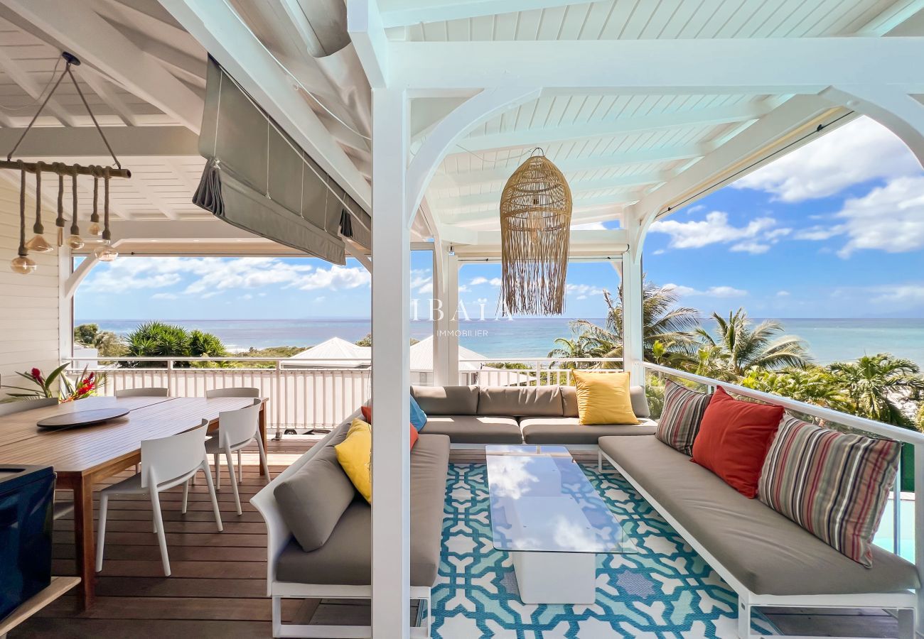 Terraza comedor mesa de madera muebles de jardín vista al mar piscina