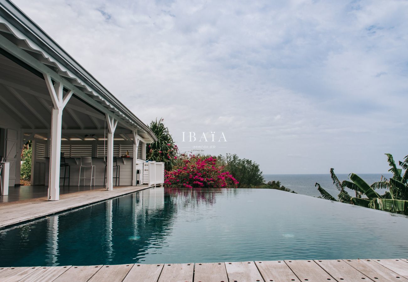 Magnífica vista desde la piscina infinita al borde de la terraza, que ofrece vistas panorámicas del océano, en una villa de lujo en las Antillas