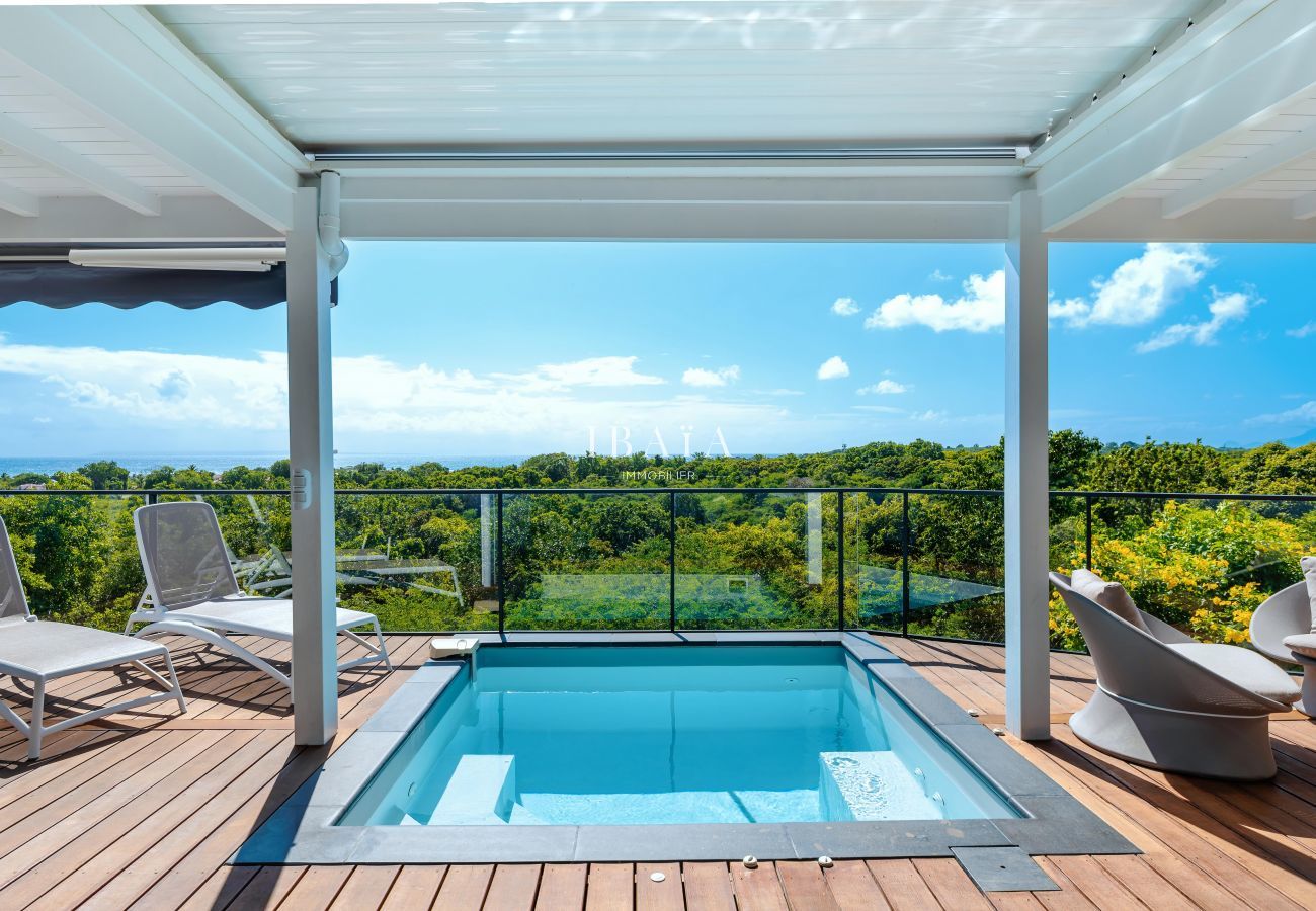 Terraza elegante con muebles modernos, piscina y vistas a la naturaleza