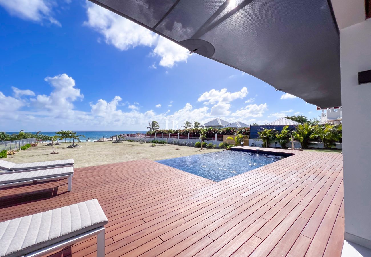 Terraza de madera con piscina y vista al mar