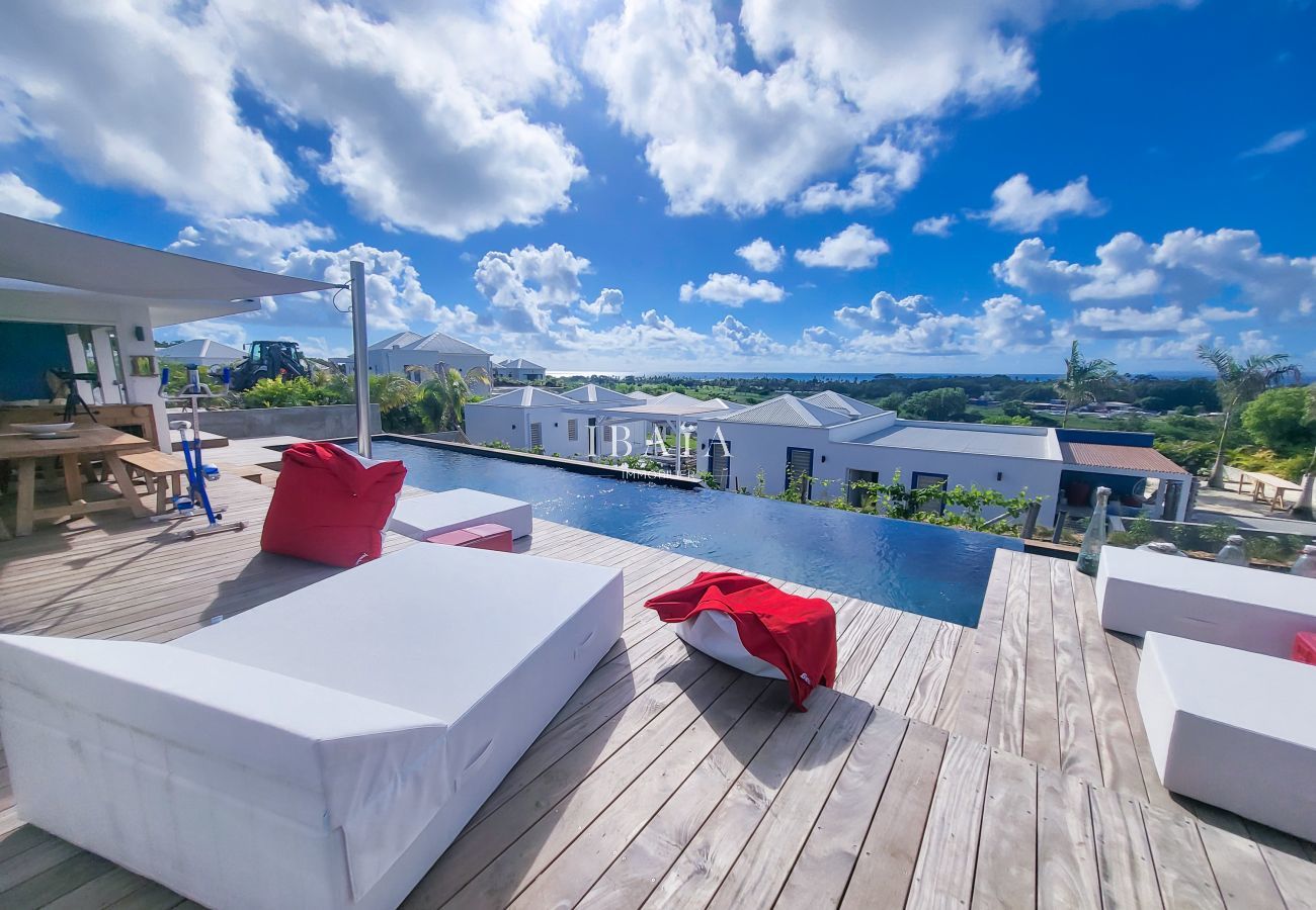 Piscina con tumbonas, vista despejada al horizonte, cielo azul