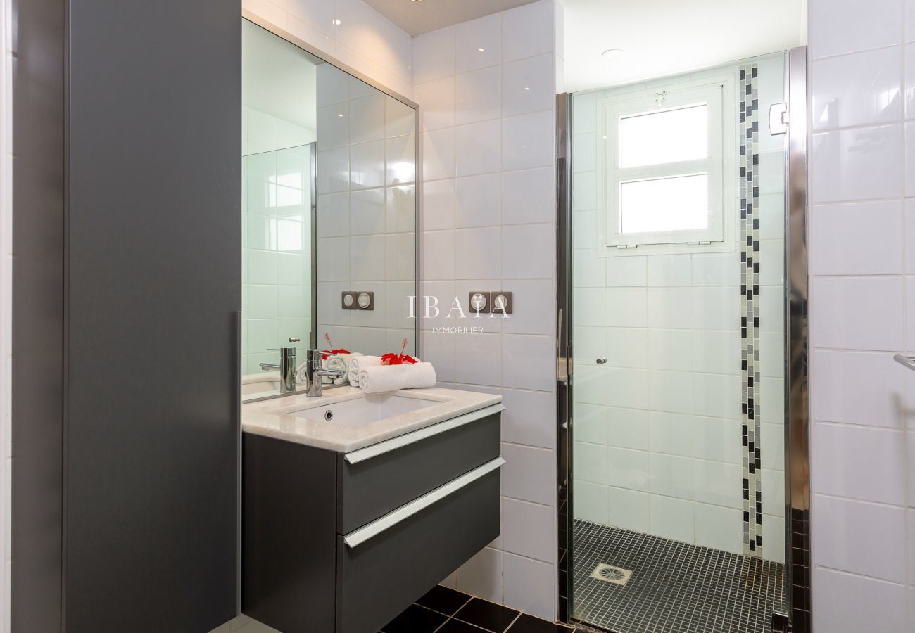 Large salle de bain avec vasque et douche à l'italienne