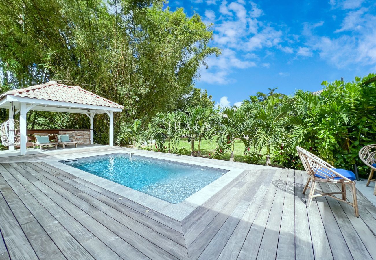 Vue de la piscine et du patio avec salon de jardin et terrasse en bois