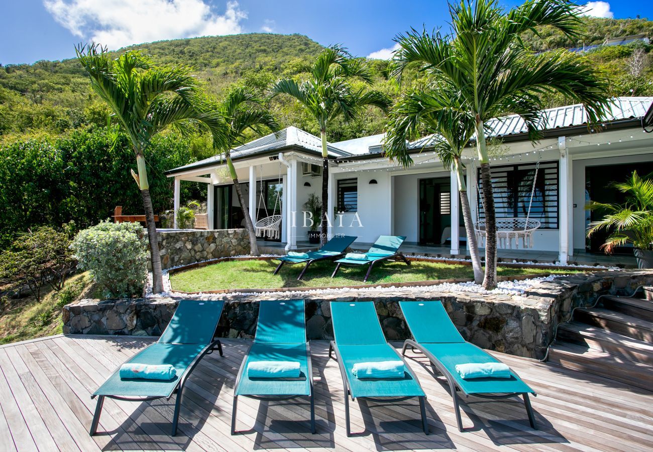 Piscine et transats à l'ombre des palmiers et cocotiers