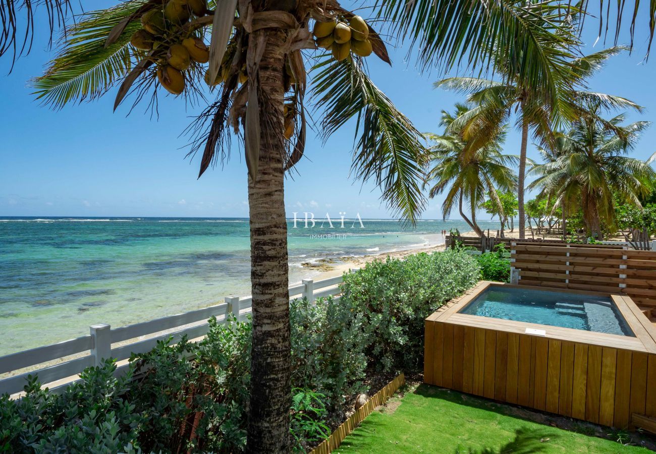 Vue depuis le jardin sur le bord de mer et la piscine de notre villa haut de gamme aux Antilles.