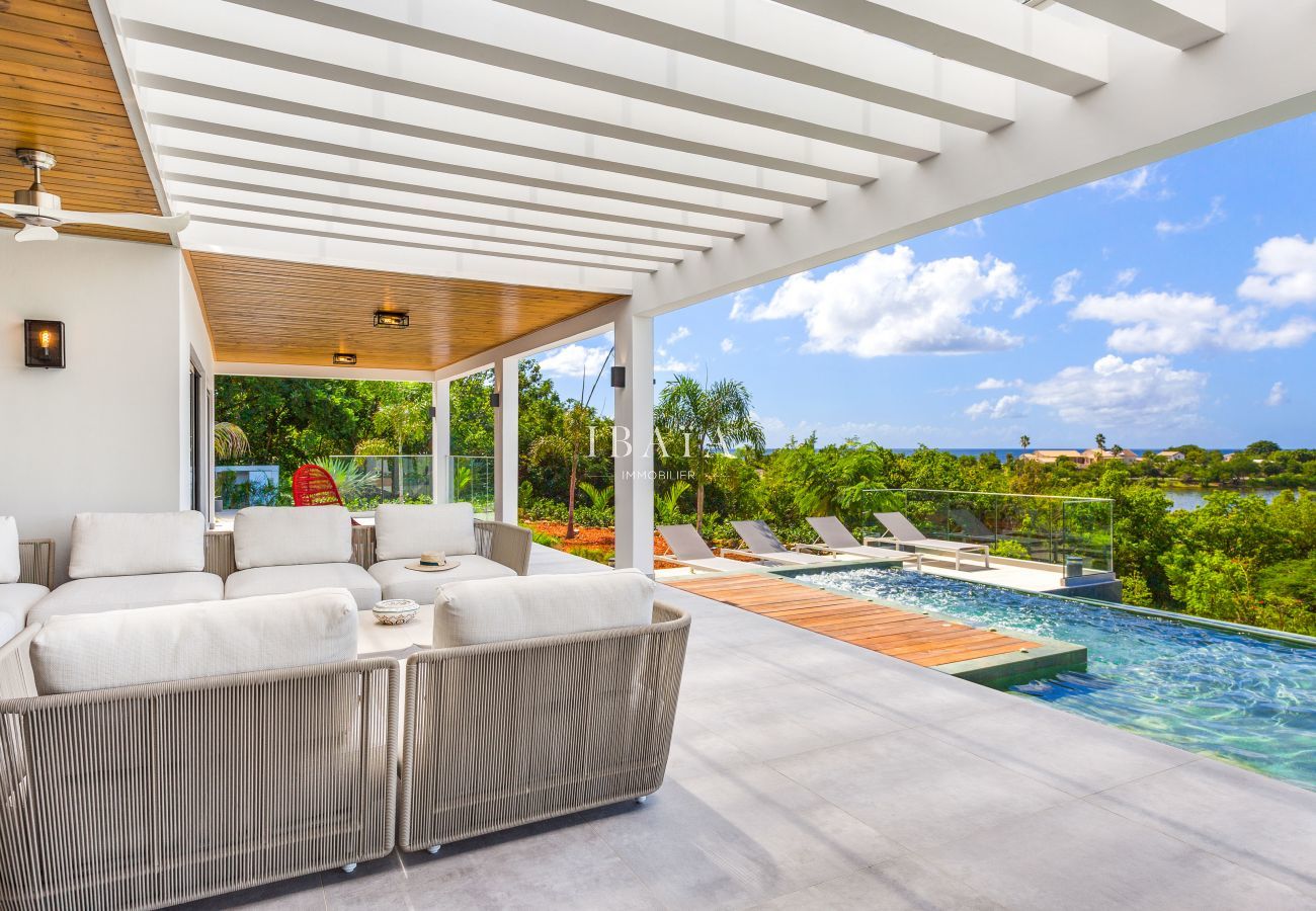 Salon d'extérieur 8 places avec piscine offrant une vue magnifique sur la mer - Villa haut de gamme aux Antilles