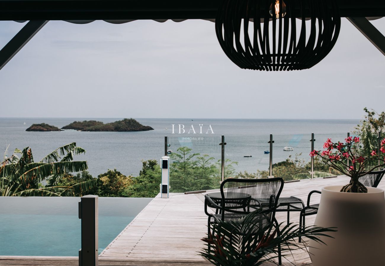 Vue imprenable depuis la terrasse et la piscine de la villa de luxe sur les îlets Pigeons, offrant un décor naturel exceptionnel aux Antilles