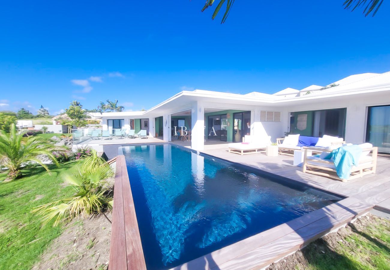 Villa moderne avec piscine à débordement et mobilier extérieur en bois